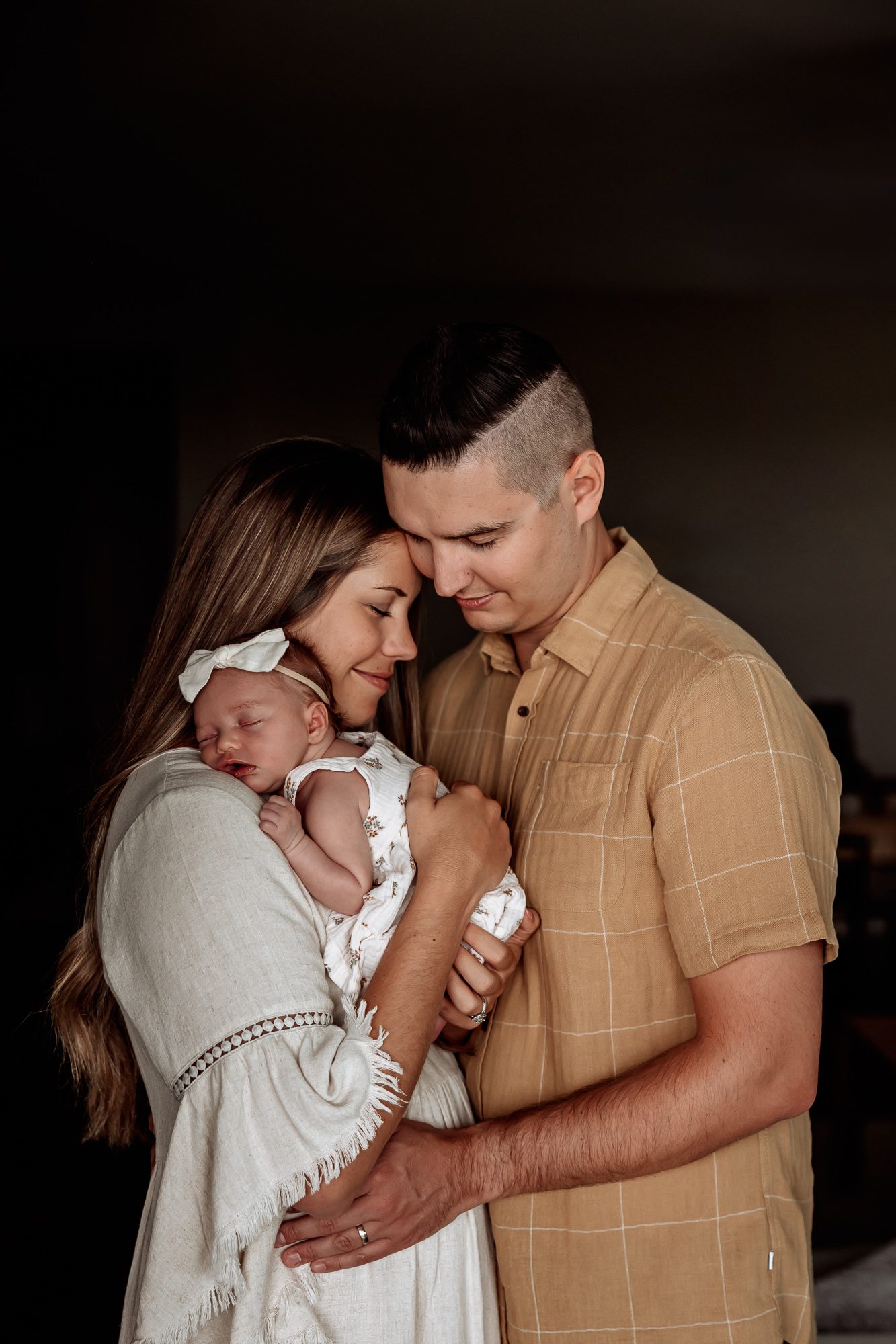 Dacono Newborn Photographer, family of three holding baby